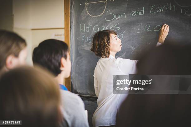 teacher writing on blackboard in science class - teacher board stock pictures, royalty-free photos & images