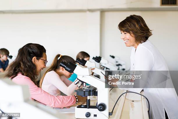 happy teacher looking at student in science class - women in stem foto e immagini stock