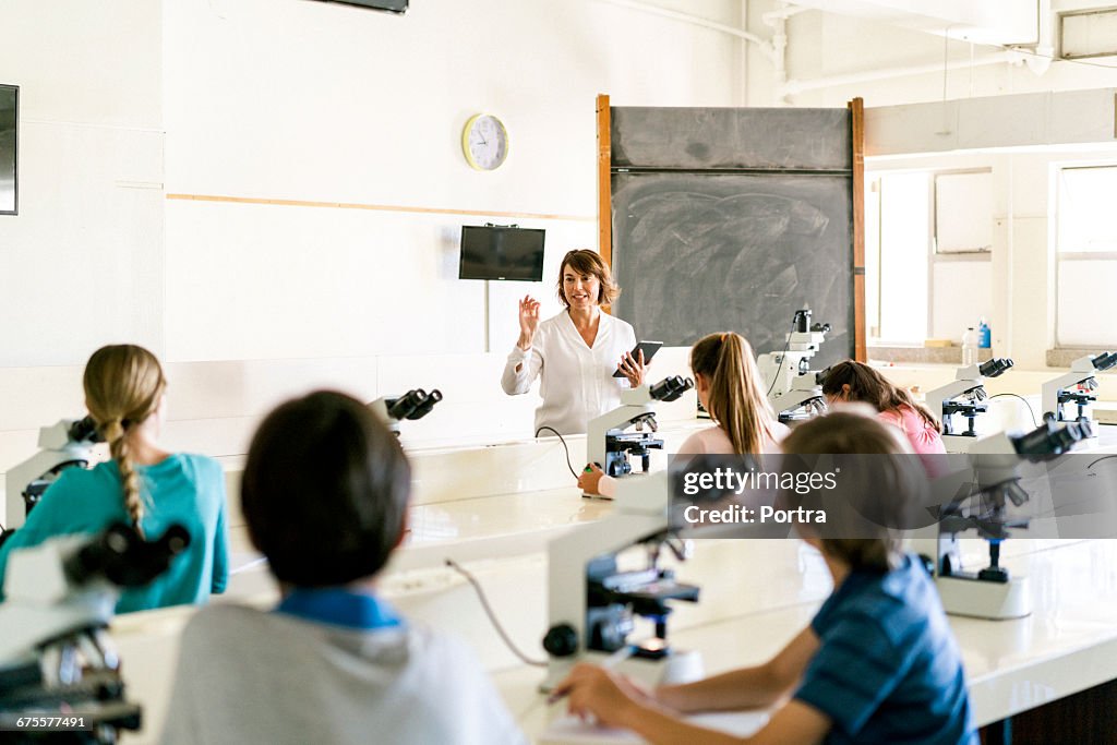 Teacher explaining students using digital tablet