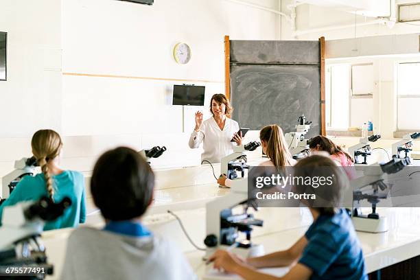 teacher explaining students using digital tablet - education science and technology stock pictures, royalty-free photos & images