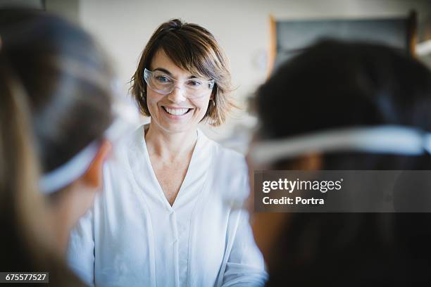 happy teacher wearing protective glasses in class - science teacher stock pictures, royalty-free photos & images