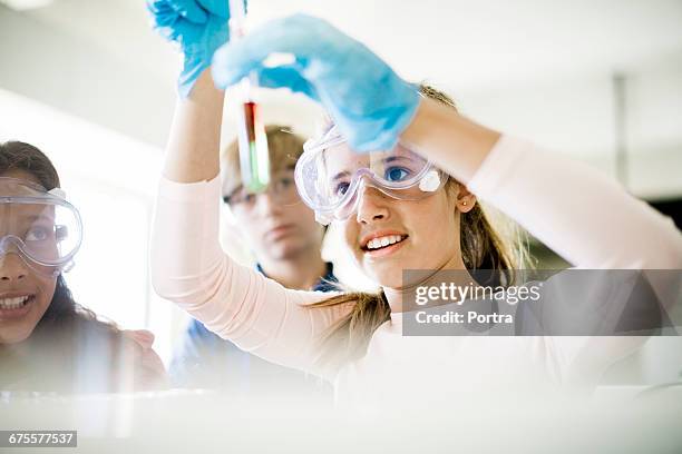 concentrated girl doing experiment in classroom - chemie stock-fotos und bilder