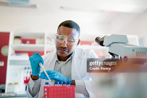 concentrated chemist mixing chemicals in test tube - laboratoriumglas stockfoto's en -beelden