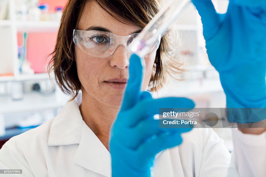 Serious chemist analyzing chemical in test tube