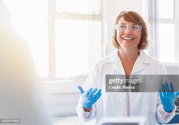 happy chemist gesturing and talking in laboratory - labor chemie stock-fotos und bilder