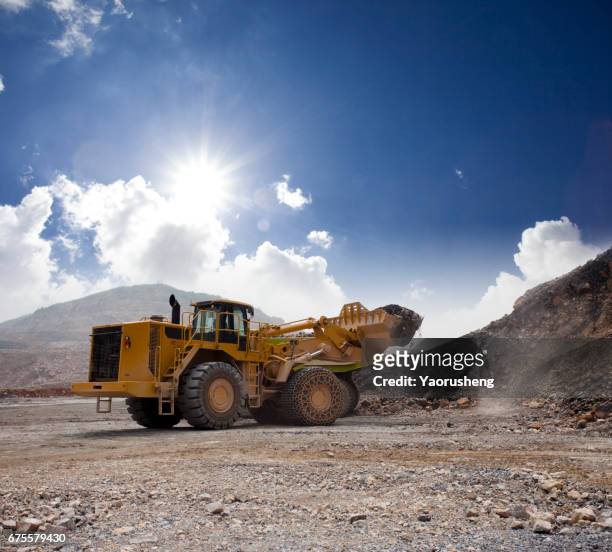 wheel loader machine unloading rocks in the open-mine of iron ore,china - gold mine stockfoto's en -beelden