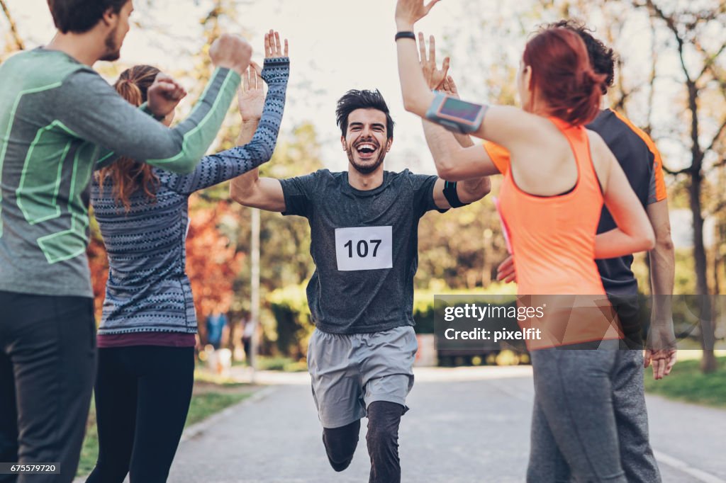Grupo de atletas de felicitación al ganador en la línea de finsh