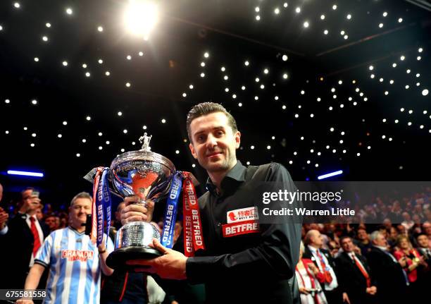 Mark Selby of England poses with the trophy after beating John Higgins of Scotland in the final of the World Snooker Championship on day seventeen at...