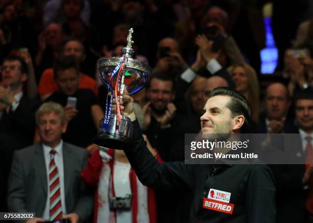 Mark Selby of England poses with the trophy after beating John Higgins of Scotland in the final of the World Snooker Championship on day seventeen at...