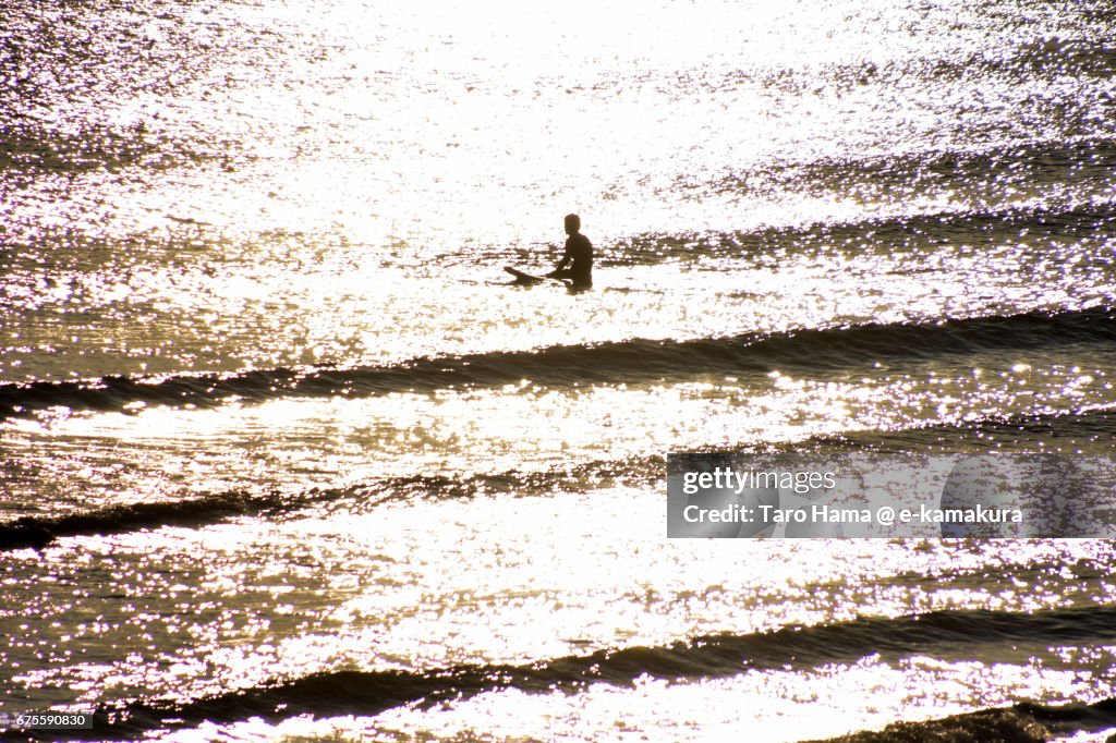 A surfer waiting for wave on the sunset beach