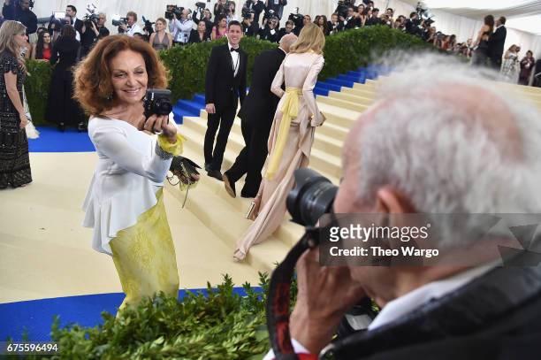 Diane Von Furstenberg takes a photo of photographer Ron Galella at the "Rei Kawakubo/Comme des Garcons: Art Of The In-Between" Costume Institute Gala...