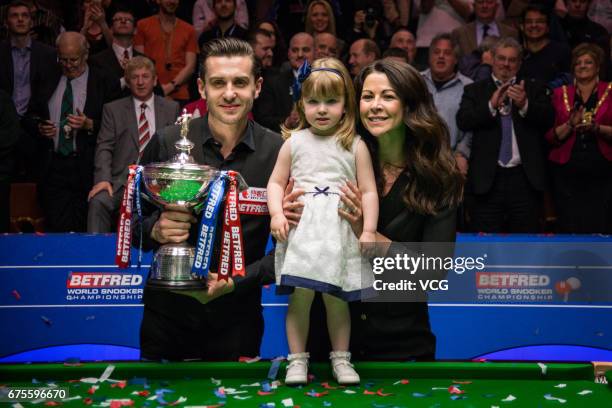 Mark Selby of England holding his trophy poses with his daughter and wife after winning the final match against John Higgins of Scotland on day...