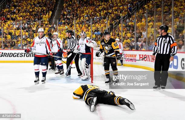 Sidney Crosby of the Pittsburgh Penguins lays on the ice injured after being cross checked in the head during the first period against the Washington...