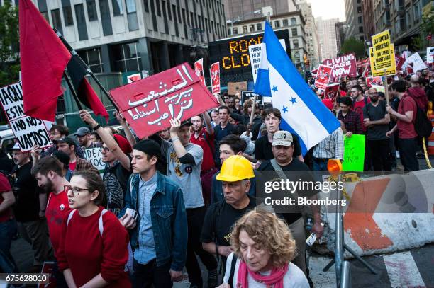 Demonstrators carry signs while marching during the May Day protest in New York, U.S., on Monday, May 1, 2017. People took to the streets throughout...