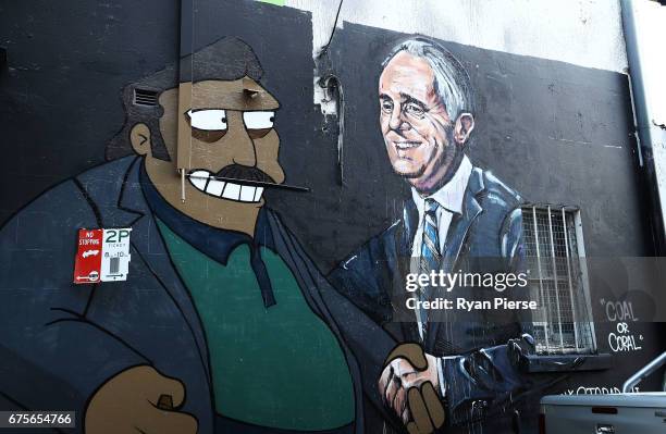 Large painted mural on the side of a building in Chippendale depicts Prime Minister Malcolm Turnbull shaking hands with The Simpsons character "Fat...