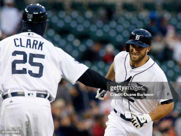 Tyler Collins of the Detroit Tigers is congratulated by third base coach Dave Clark of the Detroit Tigers after hitting a three-run home run against...