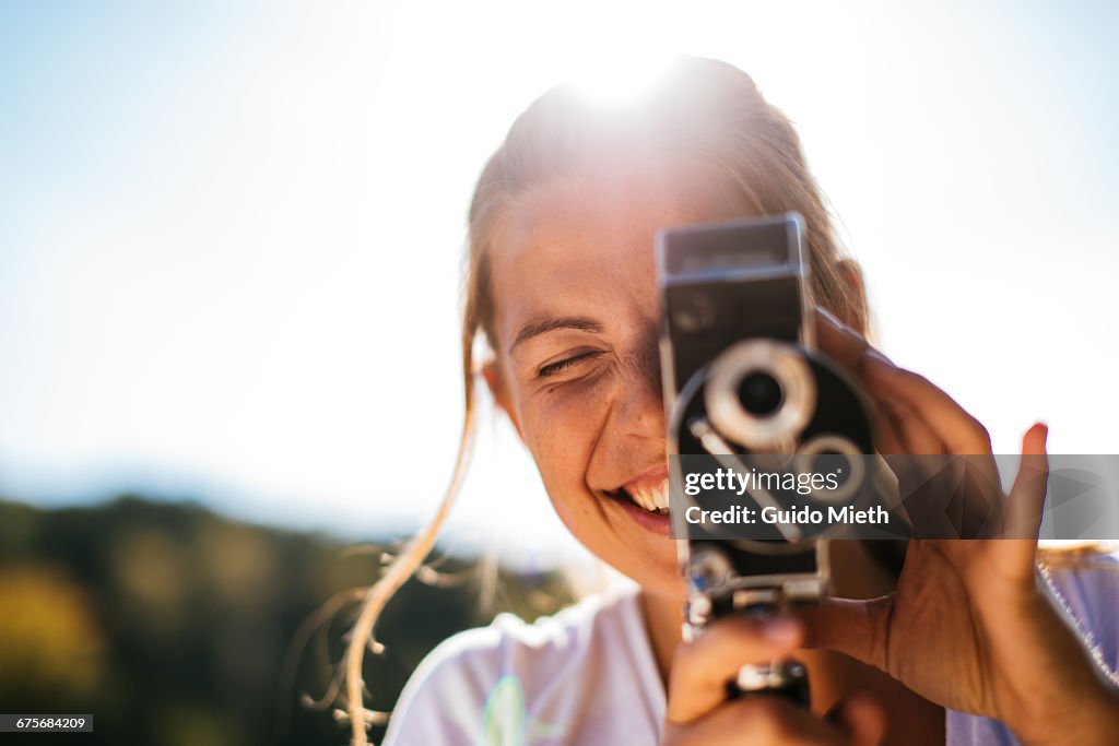 Woman filming with old camera.