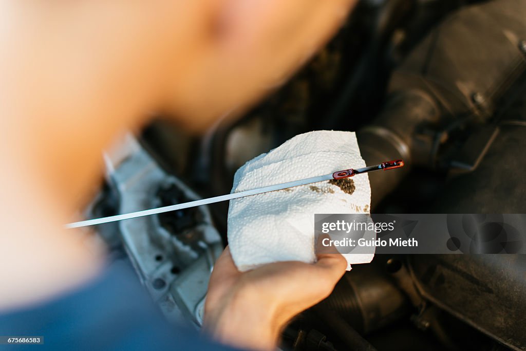 Man checking car oil.