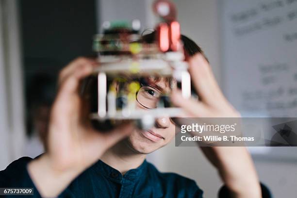 teenager admiring homemade robot - innovation stock-fotos und bilder