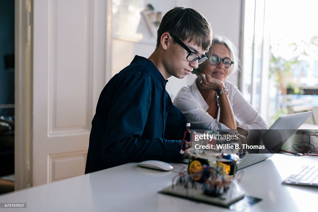 Mother helping son with computer coding