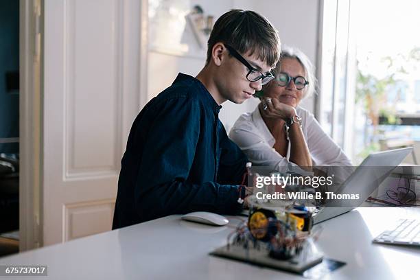 mother helping son with computer coding - teen son stock pictures, royalty-free photos & images