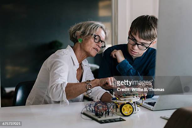 mother teaching son about electronic - 55 59 anni foto e immagini stock