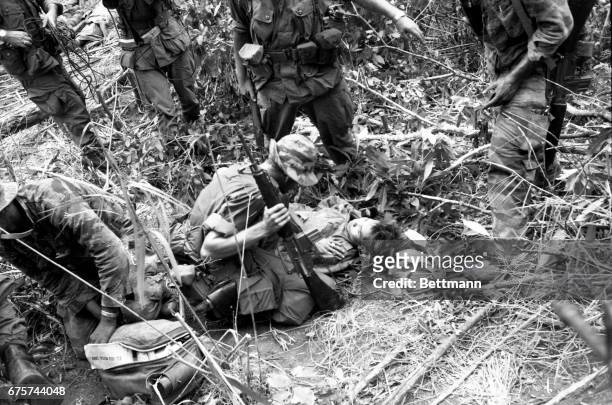 Member of the elite “Tiger” force of the 101st Airborne Brigade questions a wounded North Vietnamese captured as the brigade hacked its way through...