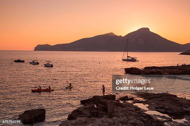 sea kayakers with sa dragonera island at sunset - middlebare afstand stockfoto's en -beelden