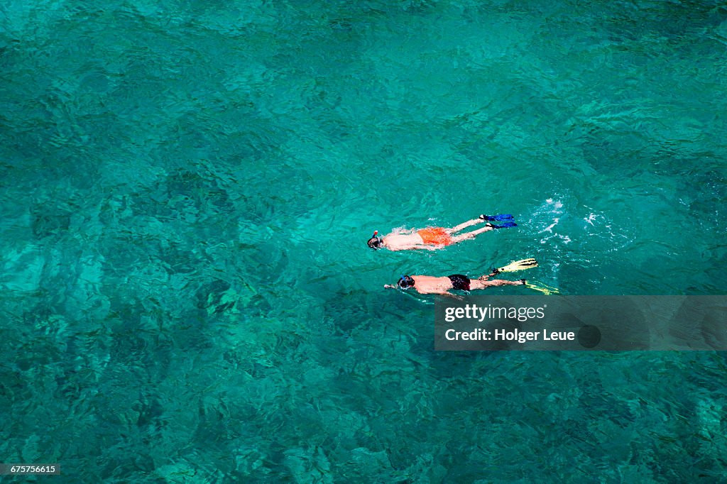Two men snorkel in clear water at Cala Pi bay