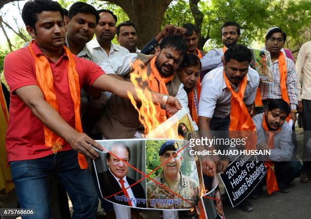 Indian activists from the right-wing organisation Hindu Sena burn posters with images of Pakistani Prime minister Nawaz Sharif and Pakistani army...