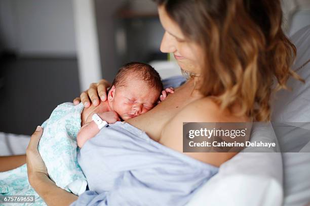 a newborn and his mother at maternity ward - mom holding baby fotografías e imágenes de stock