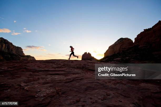 una mujer va por un sendero a campo traviesa en puesta de sol en sedona, arizona, ee. - cross country running fotografías e imágenes de stock