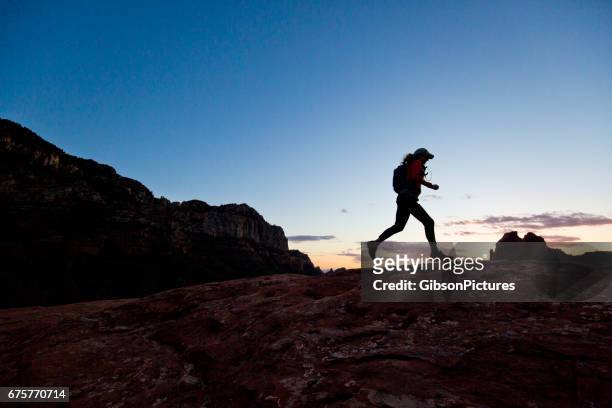 una mujer va por un sendero a campo traviesa en puesta de sol en sedona, arizona, ee. - cross country running fotografías e imágenes de stock