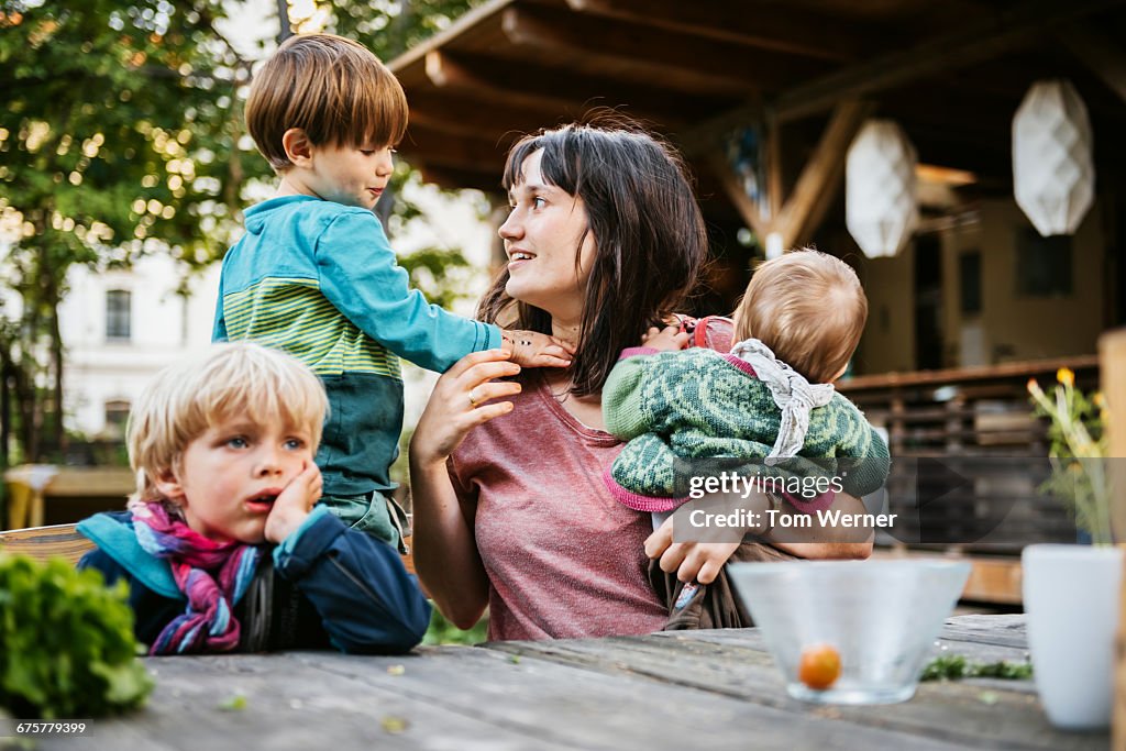 Young mother with children sitting in a community