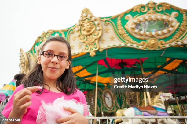 young girl eating cotton candy at the carnival - atlanta georgia food stock pictures, royalty-free photos & images