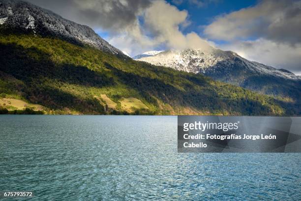 sunlight over the hills with clouds and snow during the winter andean lake crossing - luz del sol stock pictures, royalty-free photos & images