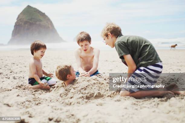 Four brothers playing in the sand at the beach