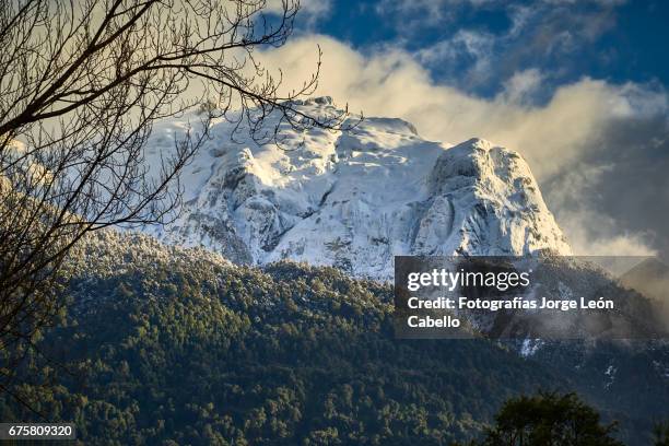 snowy cerro techado peak view from peulla in winter. - cadena de montañas stock pictures, royalty-free photos & images