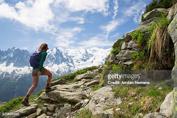 a woman hiking in the mountains. - バックパッカー ストックフォトと画像