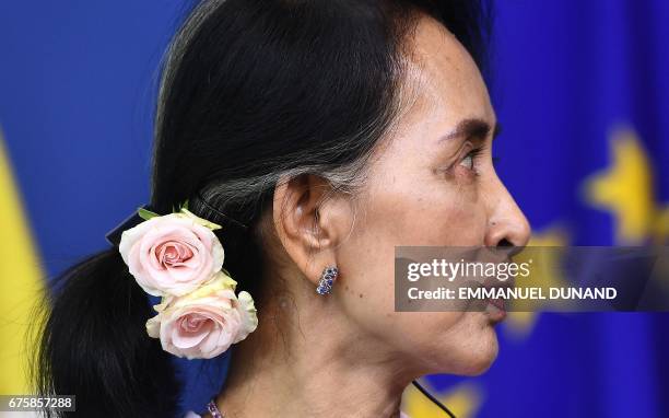 Myanmar's First State Counsellor Aung San Suu Kyi, wearing roses in her hair, addresses a press conference after her meeting with the European...