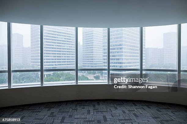 view of urban cityscape from empty business office - raamkozijn stockfoto's en -beelden