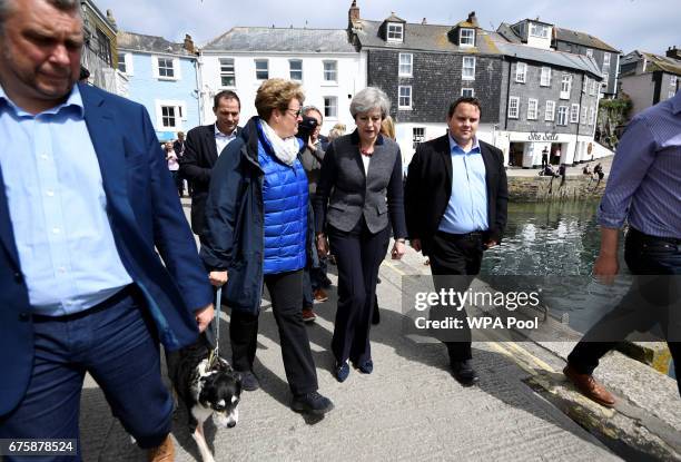 Britain's Prime Minister Theresa May walks during a campaign stop on May 2, 2017 in Mevagissey, Cornwall, England. The Prime Minister is campaigning...