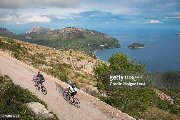 cyclists on road overlooking cap de formentor - cycling tour de stock-fotos und bilder
