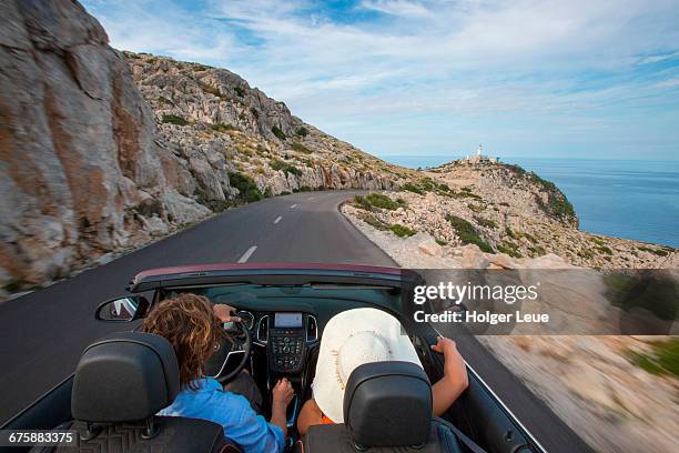 couple in convertible on road to cap de formentor - südeuropa stock-fotos und bilder
