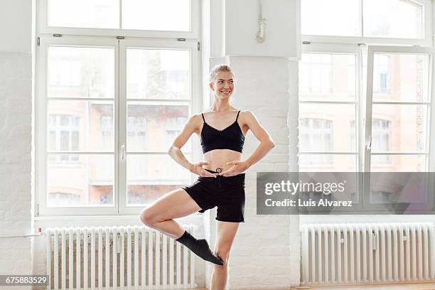 smiling female dancer practicing in studio - estudio de ballet fotografías e imágenes de stock