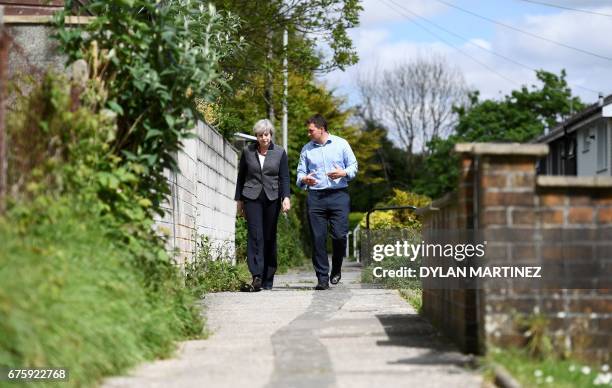 Britain's Prime Minister Theresa May talks with Conservative MP for Plymouth, Johnny Mercer, as they walk in Plymouth, south-west England, on May 2...
