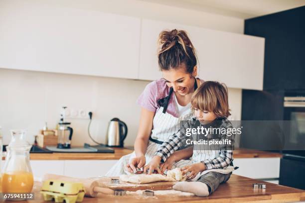 mother and son making cookies together - boy cooking stock pictures, royalty-free photos & images