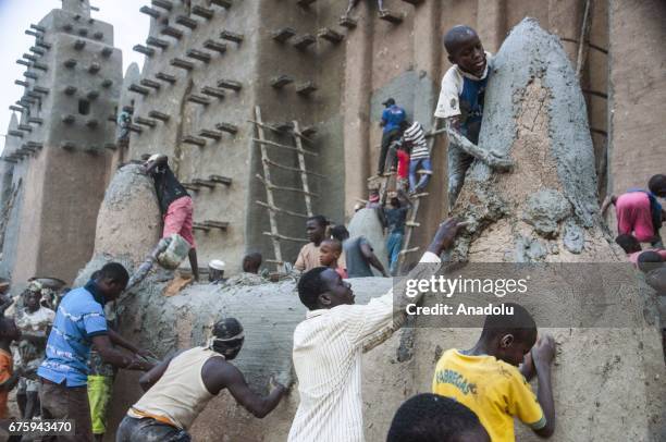 People restore Great Mosque of Djenne with Mud in Mali on April 30, 2017. The Great Mosque of Djenne listed in UNESCO as a World Heritage Site is the...