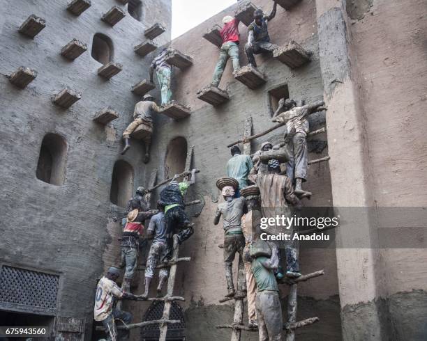 People restore Great Mosque of Djenne with Mud in Mali on April 30, 2017. The Great Mosque of Djenne listed in UNESCO as a World Heritage Site is the...
