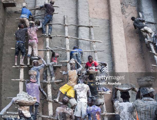 People restore Great Mosque of Djenne with Mud in Mali on April 30, 2017. The Great Mosque of Djenne listed in UNESCO as a World Heritage Site is the...